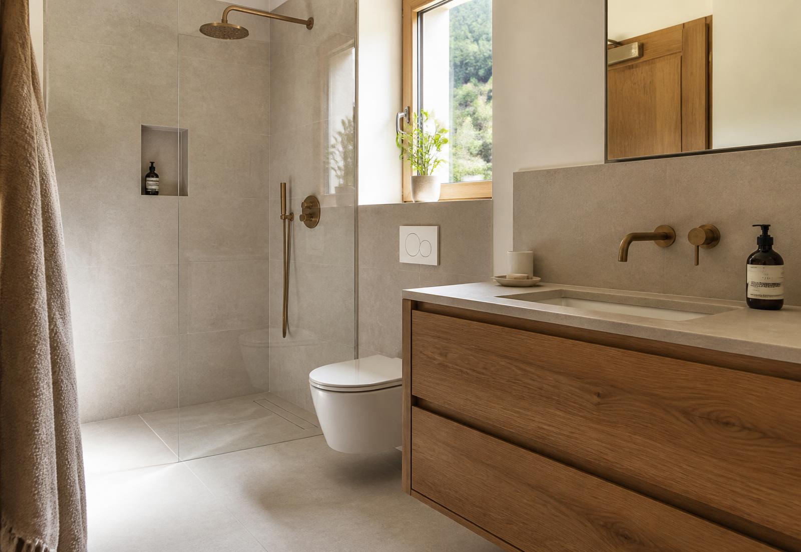 Salle de bain rénovée à Genève, lumière naturelle et matériaux chaleureux